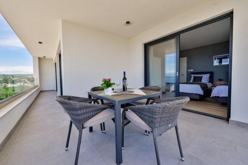 a dining room with a table and chairs and a bedroom at Apartments Lena in Malinska