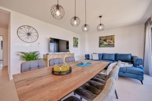 a living room with a wooden table and a blue couch at Apartments Lena in Malinska