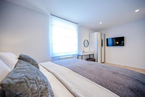 a bedroom with a bed and a television on a wall at Apartments Lena in Malinska