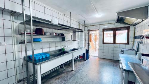 a kitchen with white tiled walls and a sink at Pensiunea Luminita in Buşteni