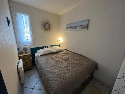 une petite chambre avec un lit et une fenêtre dans l'établissement Appartement en rez-de-chaussée avec terrasse à Narbonne Plage 4MED301, à Narbonne-Plage