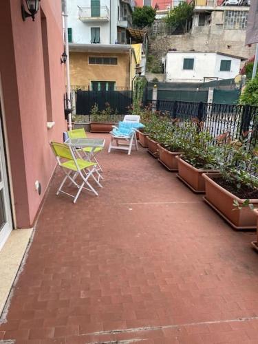 twee stoelen en een tafel op een patio met planten bij Casa Adele, vacanza relax! in Alassio