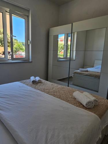 a bedroom with two beds and a large mirror at Apartmani Vuković in Rab
