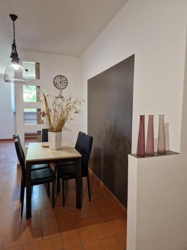 a dining room with a table and chairs and a clock at Hotel Porta Marmorea in Gubbio