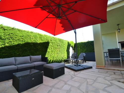 a patio with a couch and a red umbrella at Villa Villa Mallorca by Interhome in Miami Platja