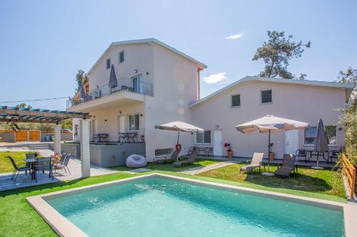 a villa with a swimming pool and a house at Privileged villa in Néa Péramos