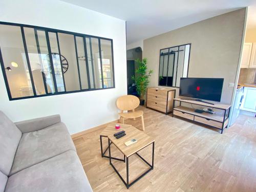 un salon avec un canapé et une télévision dans l'établissement La Bergerie By SCLS Locations, à Cannes