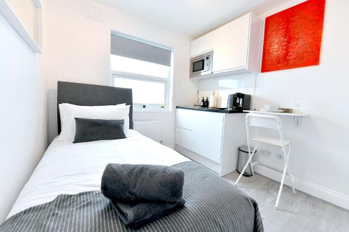 a small bedroom with a bed and a kitchen at Stylish Studios by Luxestays Fulham in London