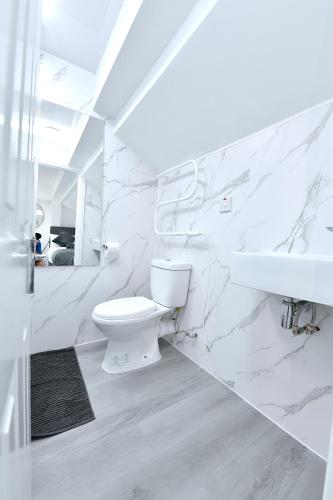 a white bathroom with a toilet and a sink at Stylish Studios by Luxestays Fulham in London