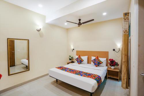 a bedroom with a large bed and a mirror at FabHotel GK Residency in New Delhi