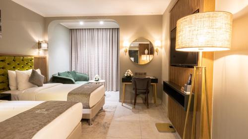 a hotel room with two beds and a desk at President Hotel in Dubai