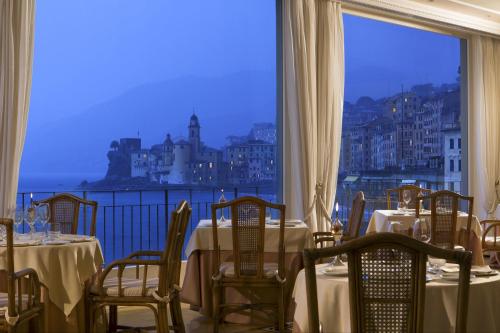 a dining room table with a balcony overlooking a city at Hotel Cenobio Dei Dogi in Camogli