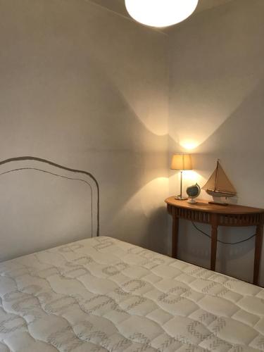 um quarto com uma cama e uma mesa com um candeeiro em La Vigie em Antibes