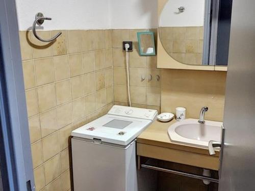 uma pequena casa de banho com um lavatório e uma máquina de lavar roupa em Appartement Bormes-les-Mimosas, 2 pièces, 5 personnes - FR-1-610-54 em Bormes-les-Mimosas