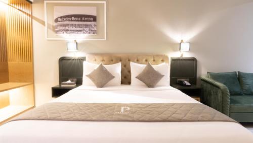 a bedroom with a large bed and a green chair at President Hotel in Dubai
