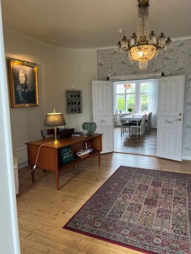 a living room with a table and a chandelier at Göta Hotell in Borensberg