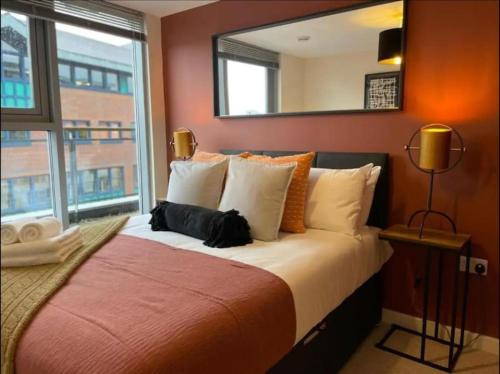 a bedroom with a large bed with a large mirror at Paramount city living 105 in Swindon