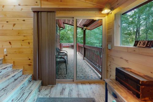 a screened porch in a log cabin with a sliding glass door at Peach Creek Lodge in Kiker