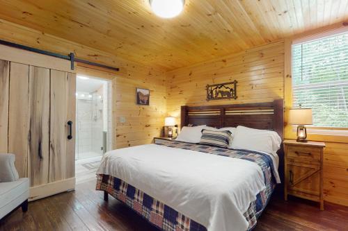 ein Schlafzimmer mit einem Bett in einer Holzhütte in der Unterkunft Peach Creek Lodge in Kiker