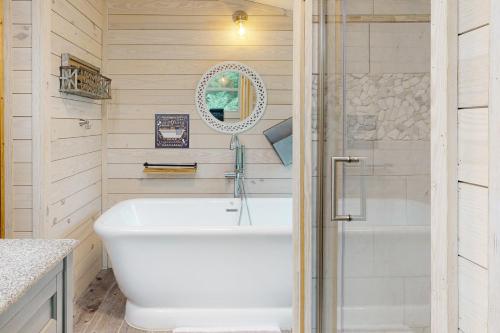 a white tub in a bathroom with a shower at Peach Creek Lodge in Kiker