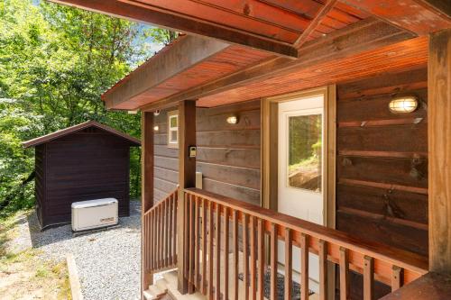 a wooden cabin with a porch and a door at Peach Creek Lodge in Kiker
