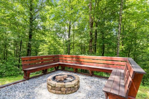 a wooden bench sitting next to a fire pit at Peach Creek Lodge in Kiker