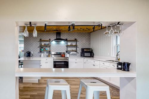 a large kitchen with white cabinets and white stools at Belleview Lakehouse in Ocklawaha