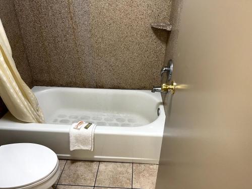 a bathroom with a bath tub and a toilet at Budget Plaza Motel in Brooklyn Park