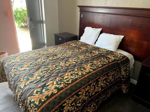 a bedroom with a bed with a wooden headboard at Budget Plaza Motel in Brooklyn Park