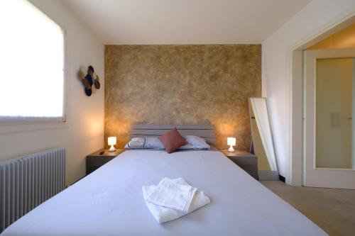 MartignaccoにあるAffittacamere Mi Sueño, tranquillità nella naturaのベッドルーム1室(大きな白いベッド1台、キャンドル2本付)