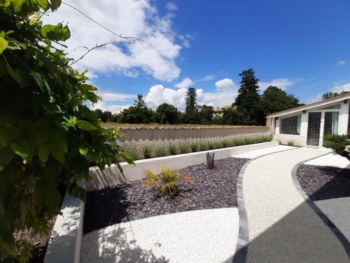 a garden with a fence and a walkway at Un petit coin de paradis à Haute Jarrie in Jarrie