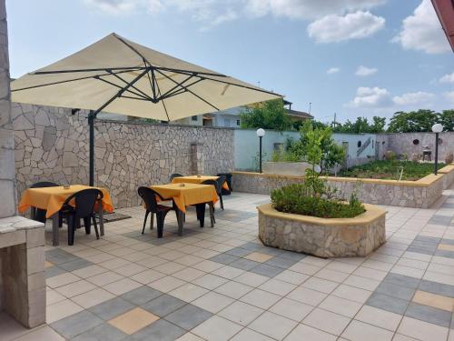 a patio with tables and chairs and an umbrella at Oltremare in Vignacastrisi