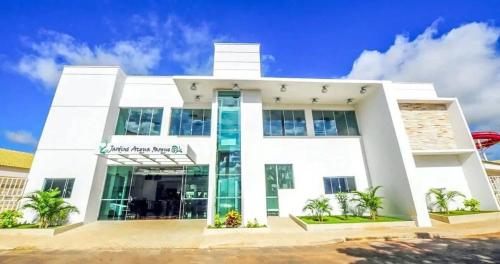 a white building with palm trees in front of it at Ap Completo Parq. Aquát. Sensacional Grátis in Caldas Novas