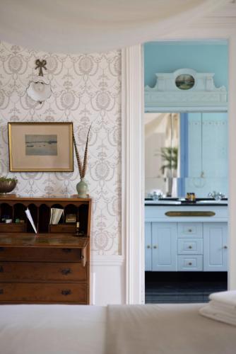 une chambre avec un lit, un lavabo et un miroir dans l'établissement Chambre d’hôtes au Château Le Bas Bleu, Anaïs Nin, à Quesnoy-le-Montant