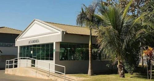 a building with a palm tree in front of it at Ap Completo Parq. Aquát. Sensacional Grátis in Caldas Novas