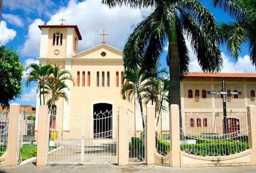 a church with palm trees in front of a fence at Ap Completo Parq. Aquát. Sensacional Grátis in Caldas Novas