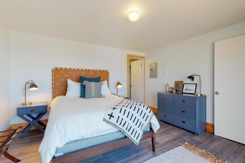 a bedroom with a large bed and a blue dresser at Cape Cod Cottages - #2 in Waldport