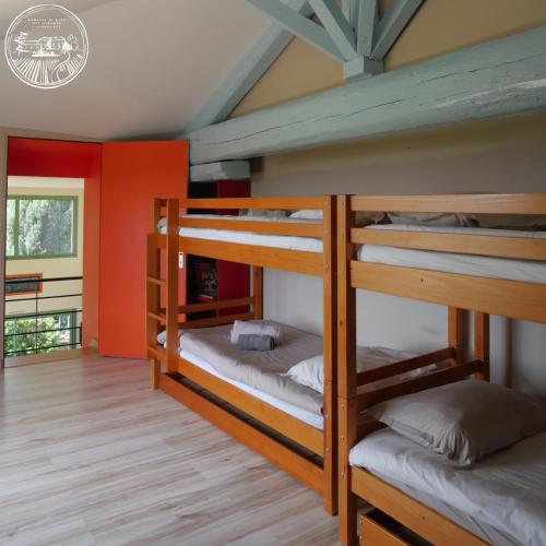 - 2 lits superposés dans un dortoir aux murs rouges dans l'établissement Gîte de la vieille vigne, à Fleurie