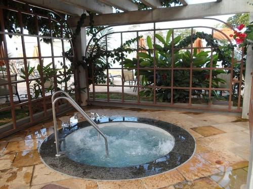 a hot tub in a room with a garden at Ap Completo Parq. Aquát. Sensacional Grátis in Caldas Novas