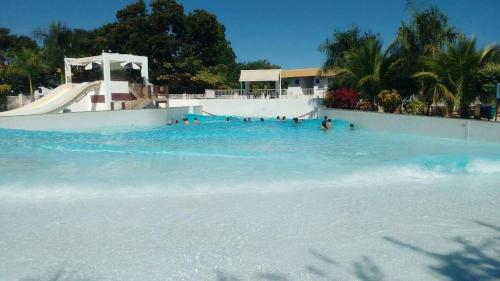 a group of people in a swimming pool with a slide at Ap Completo Parq. Aquát. Sensacional Grátis in Caldas Novas
