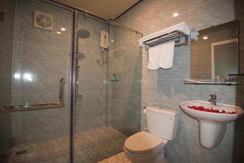 a bathroom with a shower and a toilet and a sink at Sunlight Bungalow in Phú Quốc