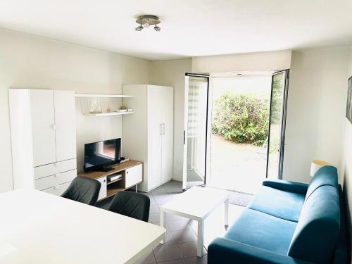 un salon avec un canapé bleu et une télévision dans l'établissement Studio plage parking et proche vieil antibes, à Antibes