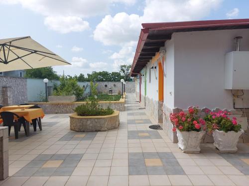 a patio with a table and chairs and an umbrella at Oltremare in Vignacastrisi