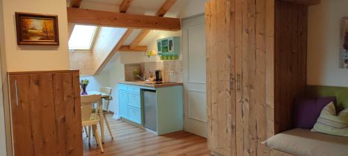 a small kitchen with blue cabinets and a small table at Pension Berghof in Brannenburg