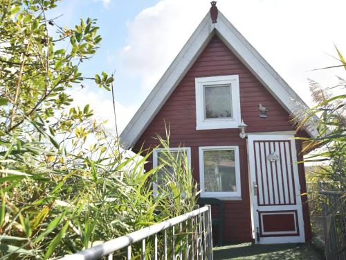 シュテルンベルクにあるStriking Holiday Home in Sternberg with Jettyの白い扉と柵の赤い家