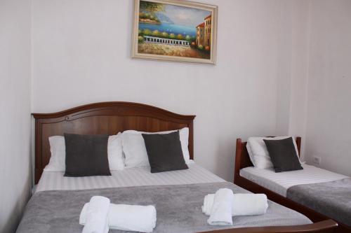 una camera con due letti e una foto a parete di Deni Family Apartament a Tirana