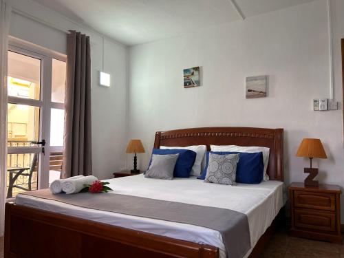 a bedroom with a large bed with blue pillows at Paradise Hill in Grand Baie