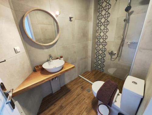 a bathroom with a sink and a mirror and a toilet at Frezia House in Kalamaki Chanion