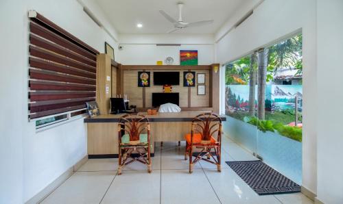a room with a bar with two chairs and a bed at Treebo Trend Majestic Retreat in Varkala