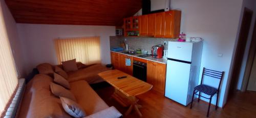 a kitchen with a couch and a table and a refrigerator at Къща за гости Джамбазови in Sarnitsa